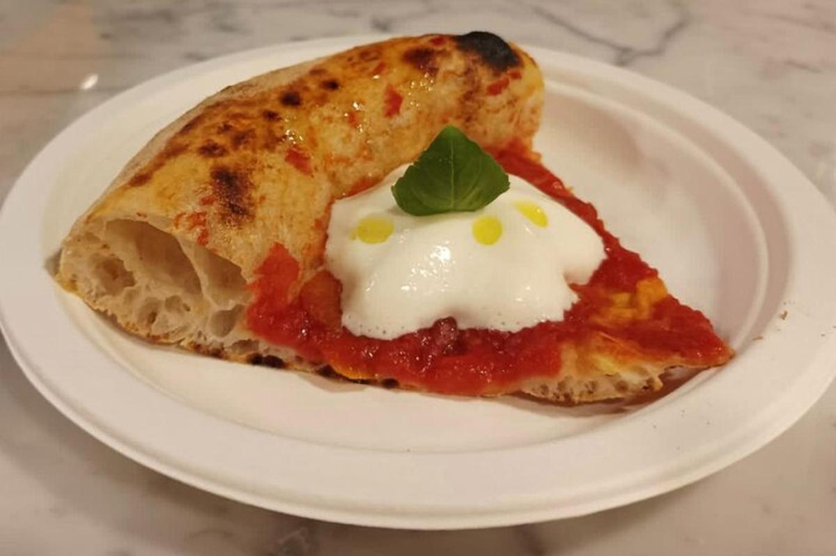 una fetta di pizza su un piatto bianco