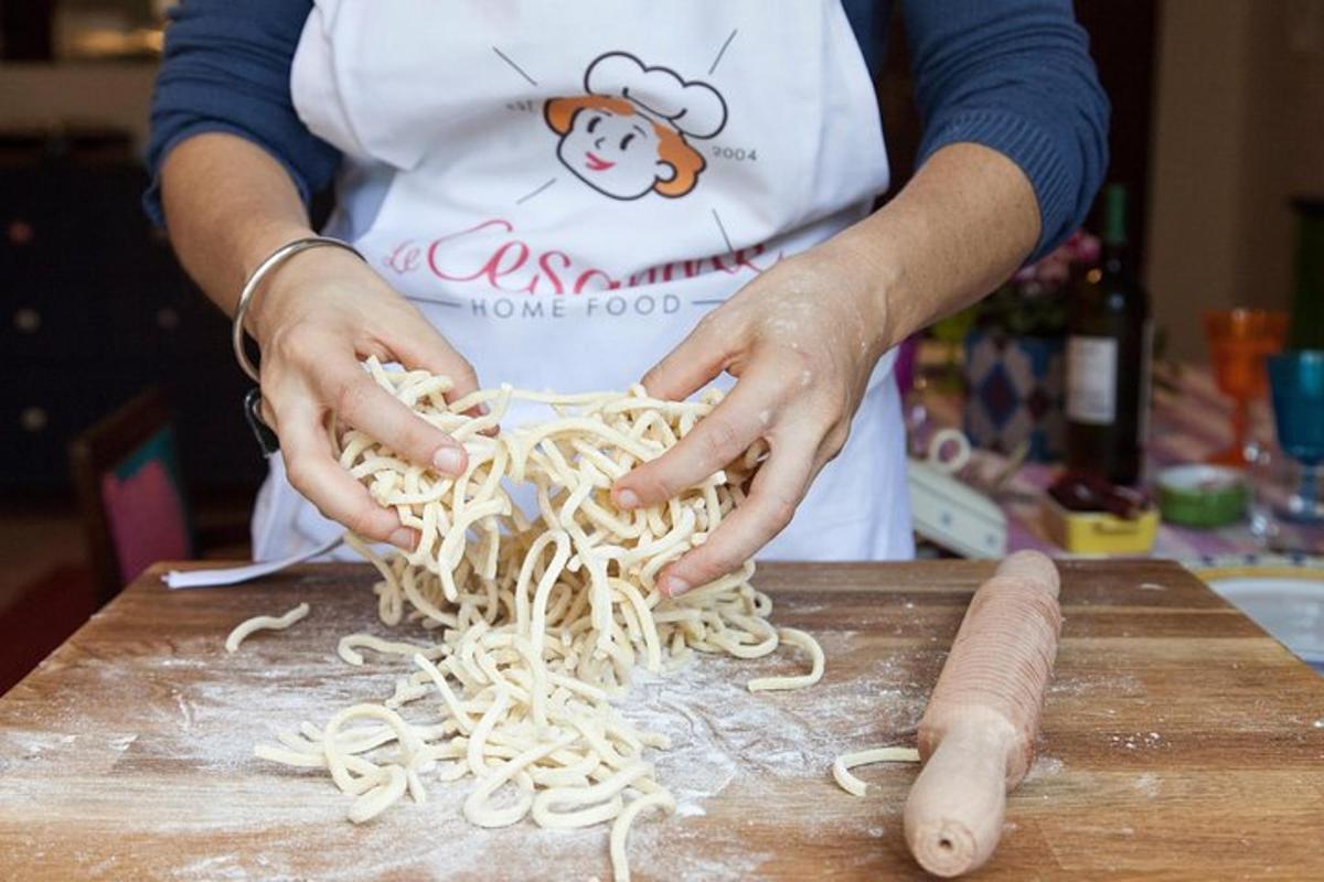 a person is preparing noodles on a cutting board
