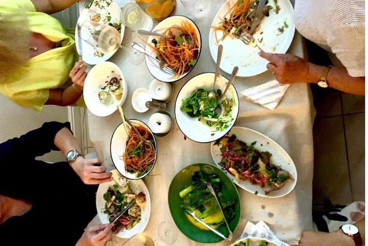 a group of people sitting around a table with plates of food