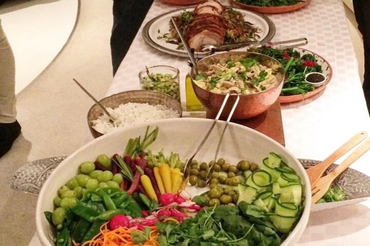 a table with a bowl of vegetables and other plates of food