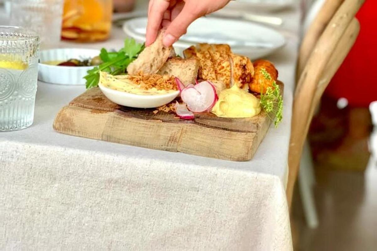 a person reaching for a plate of food on a table