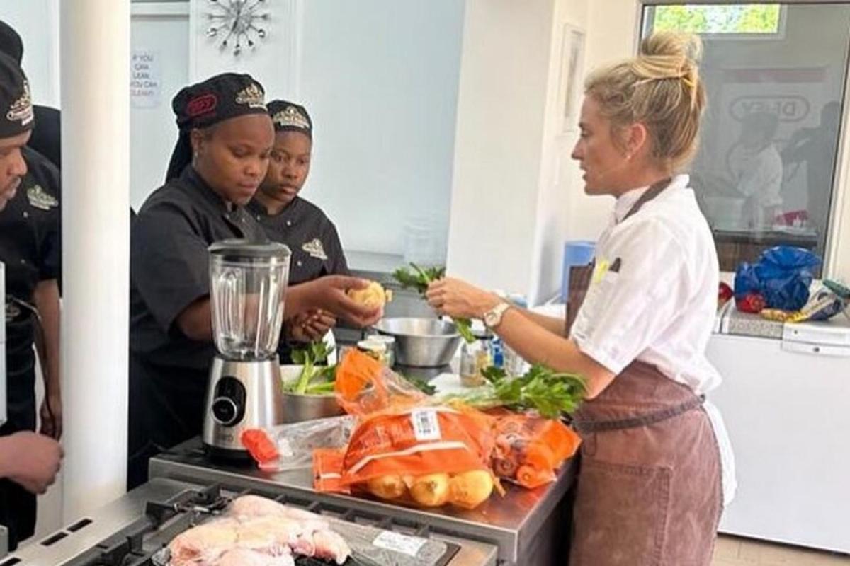 a woman standing in a kitchen preparing food