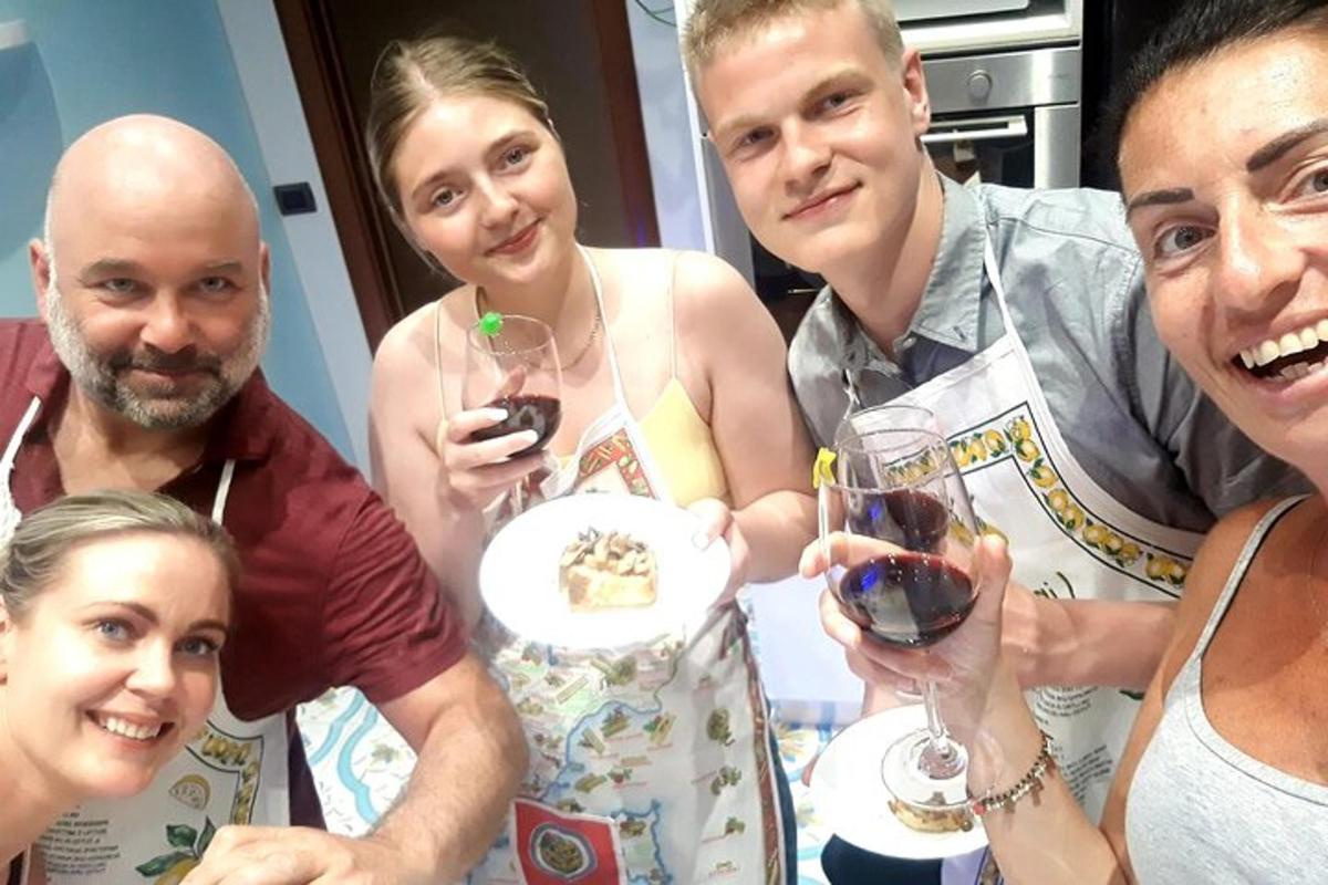 skupina lidí pózujících pro fotografii se sklenicemi na víno