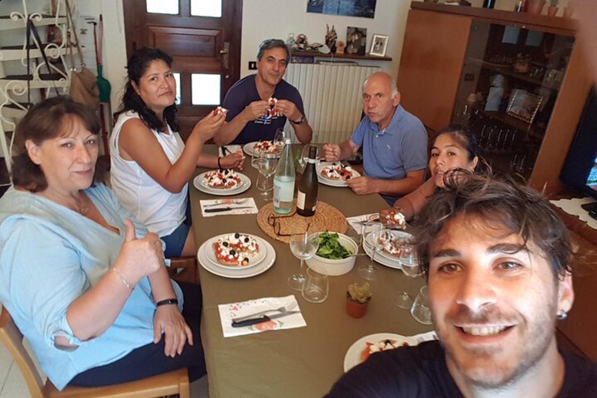 un gruppo di persone sedute attorno a un tavolo che mangiano cibo