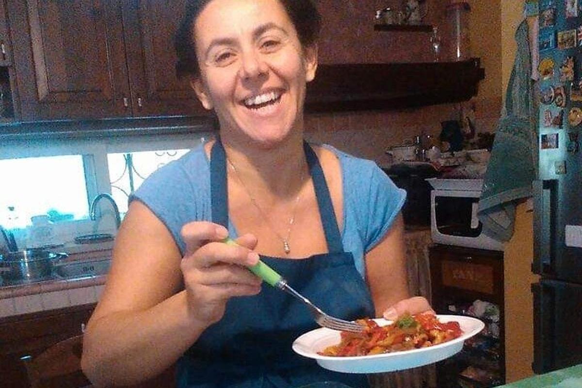 una dona que sosté un plat de menjar amb una forquilla