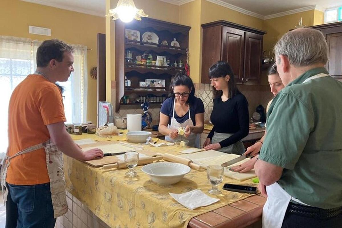 grupa ljudi stoji u kuhinji i priprema hranu