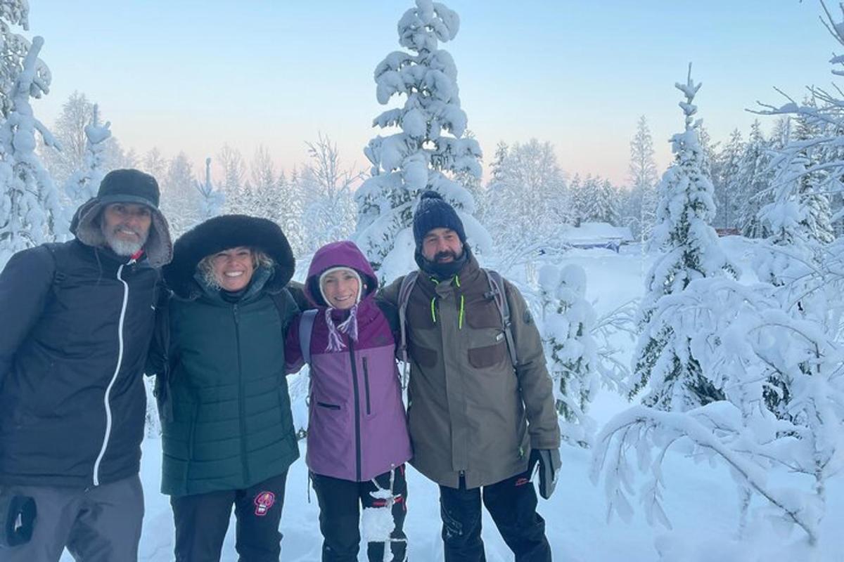 a group of people standing in front of a snow covered tree