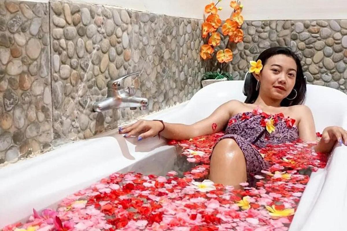 a woman laying in a bath tub covered in flowers