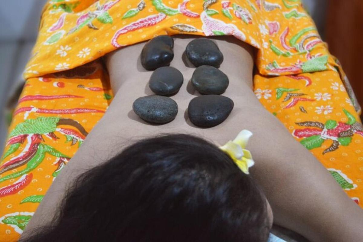 một cậu bé nằm trên giường với những tảng đá trên lưng