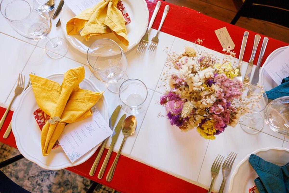 Una mesa con platos de comida, tenedores y vasos.