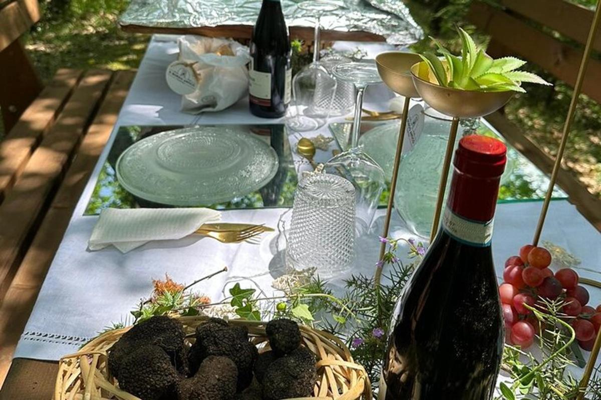 una taula amb una cistella de menjar i una ampolla de vi
