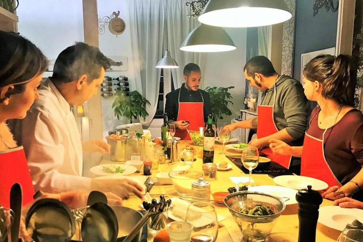 skupina lidí stojících kolem stolu a připravujících jídlo