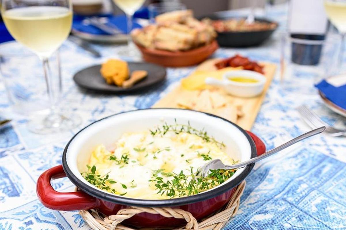 a bowl of food on a table with a glass of wine