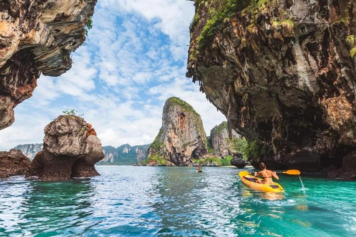 seseorang dalam kayak di dalam air antara batu