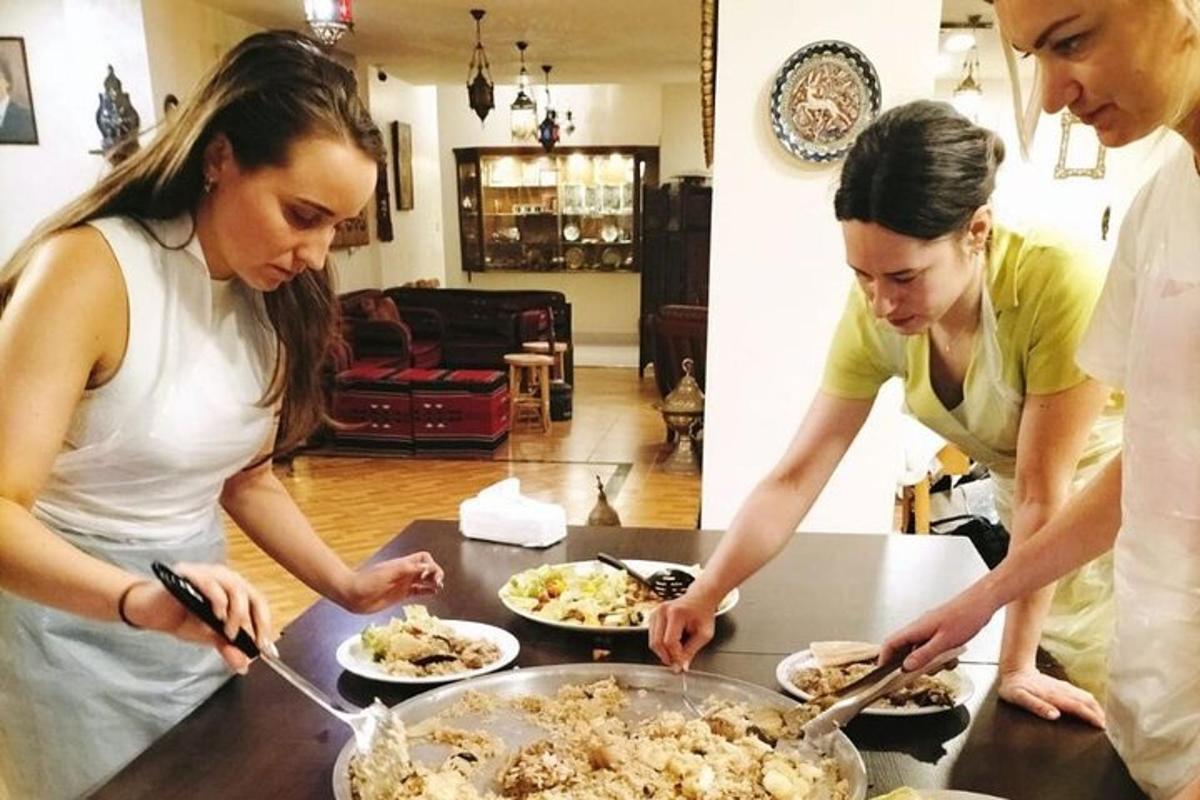 dalawang babaeng nakatayo sa isang mesa na naghahanda ng pagkain