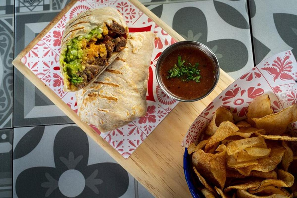 un panino su un tagliere con patatine e salsa