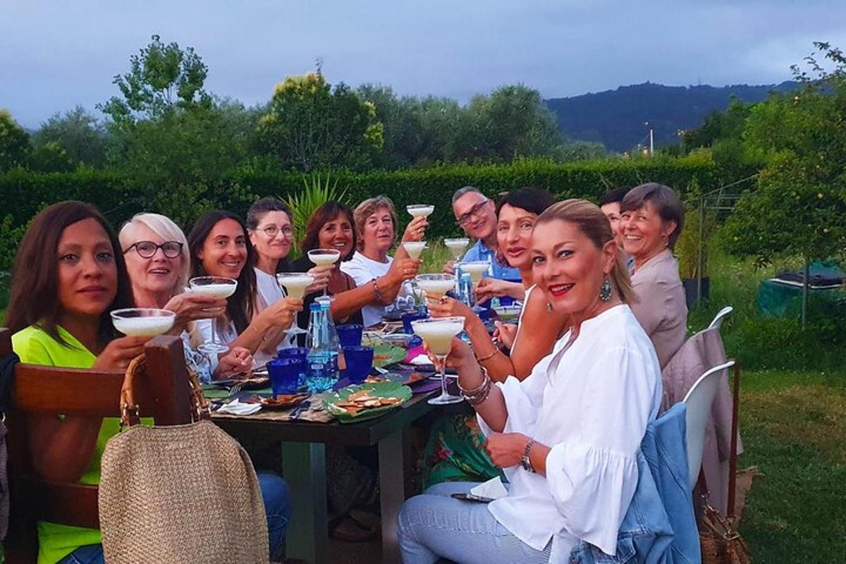 un gruppo di persone sedute a un tavolo che bevono vino