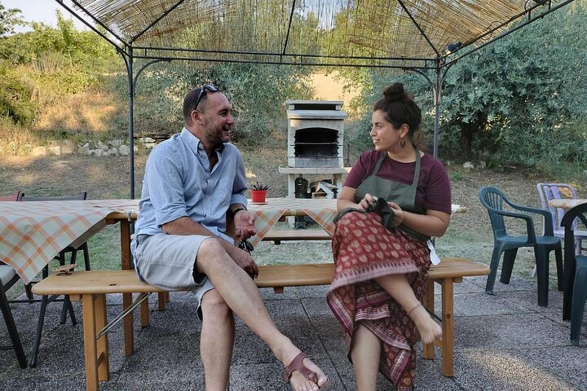a man and a woman sitting on a picnic table with an umbrella