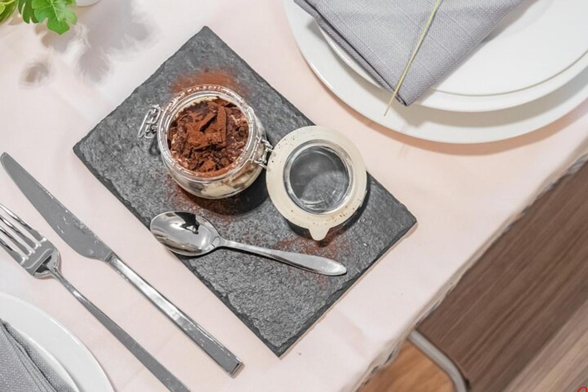 Una mesa con una cuchara y un tarro de chocolate.