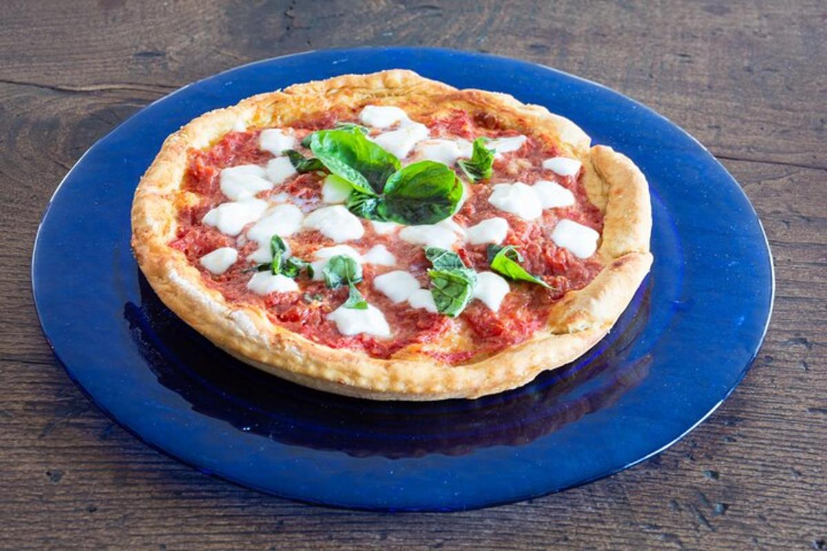 isang pizza sa isang asul na plato sa isang mesa