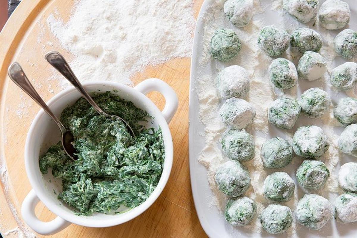 a cup of pesto next to a plate of food