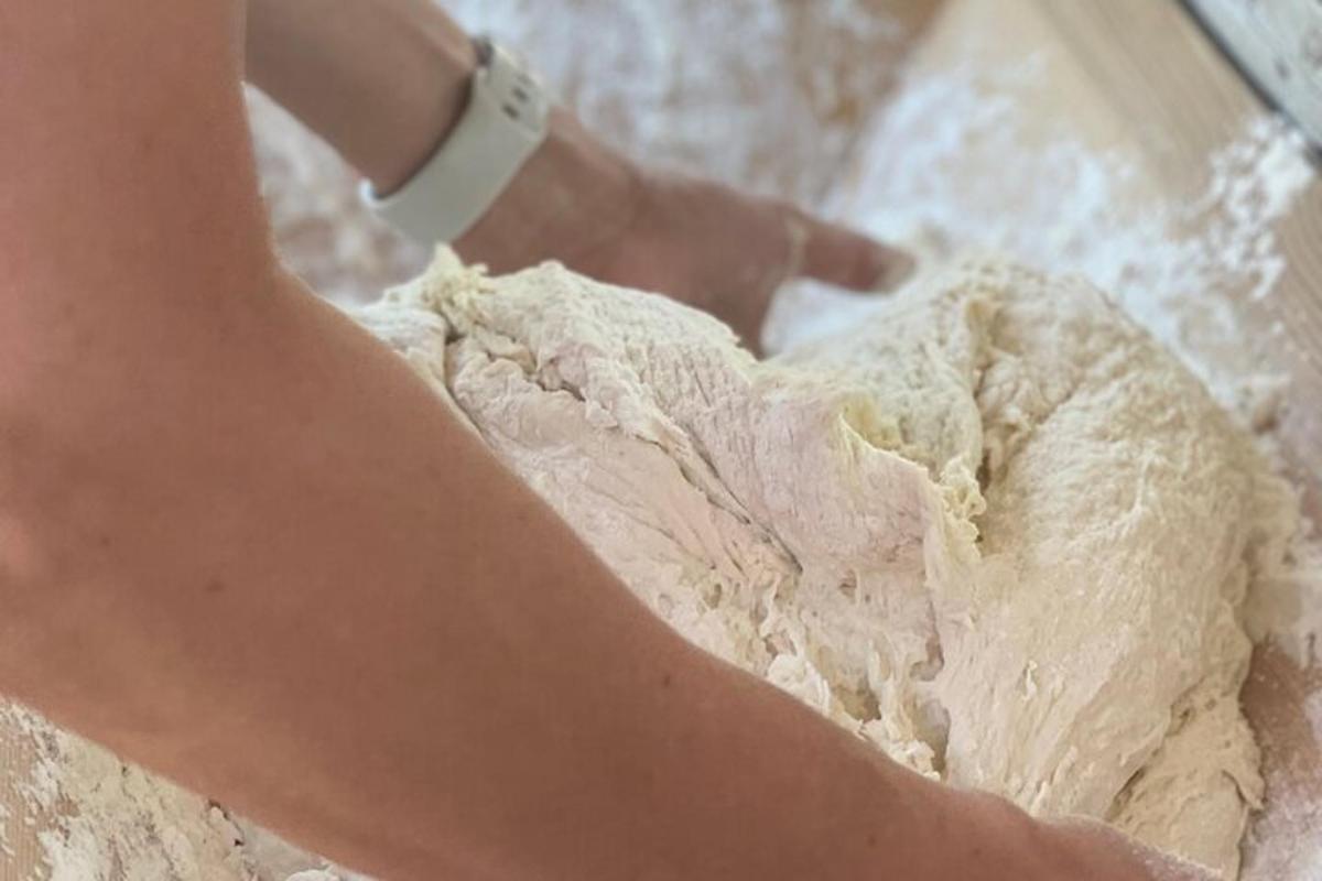 una donna sta impastando un pezzo di pane