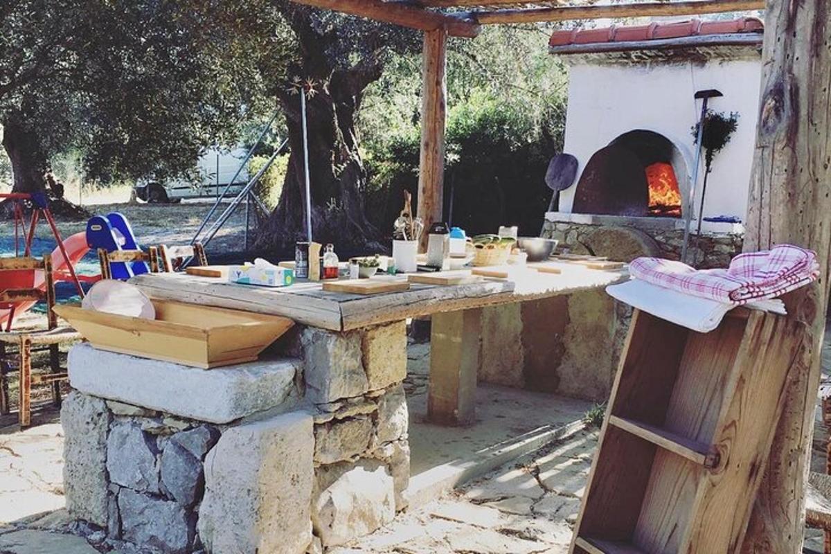 un tavolo di pietra con un forno per pizza in un cortile