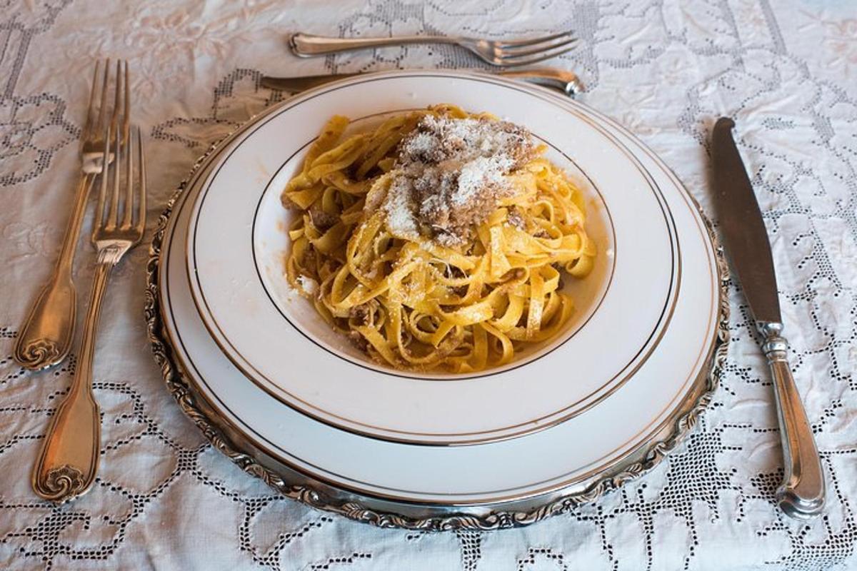 a plate of pasta on a table with silverware