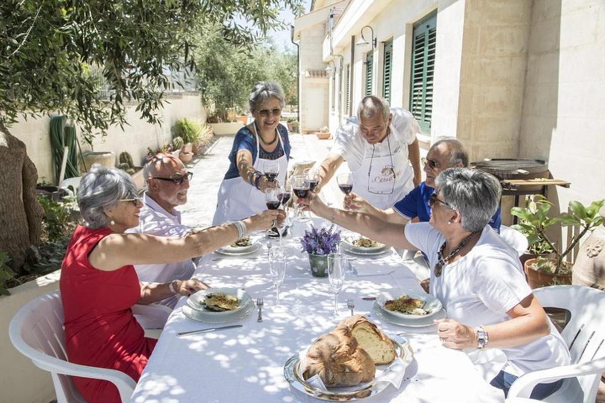 un gruppo di anziani seduti attorno a un tavolo con del cibo