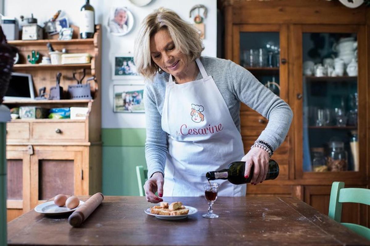 en kvinde i et køkken hælder et glas vin op
