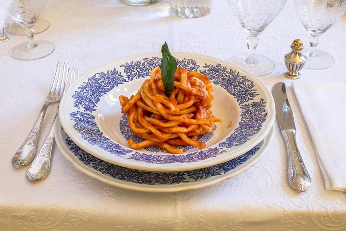 a plate of pasta on a table with silverware