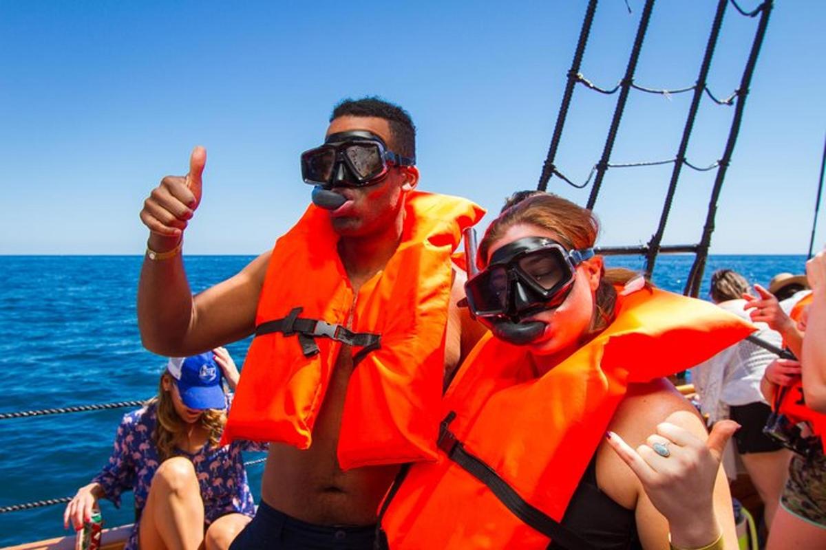 a group of people in orange life jackets on a boat