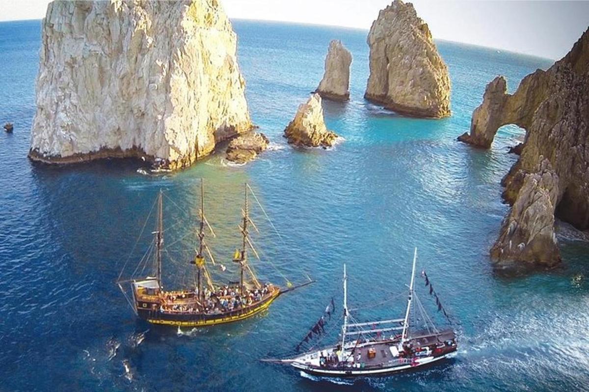 two boats in the water next to some rocks