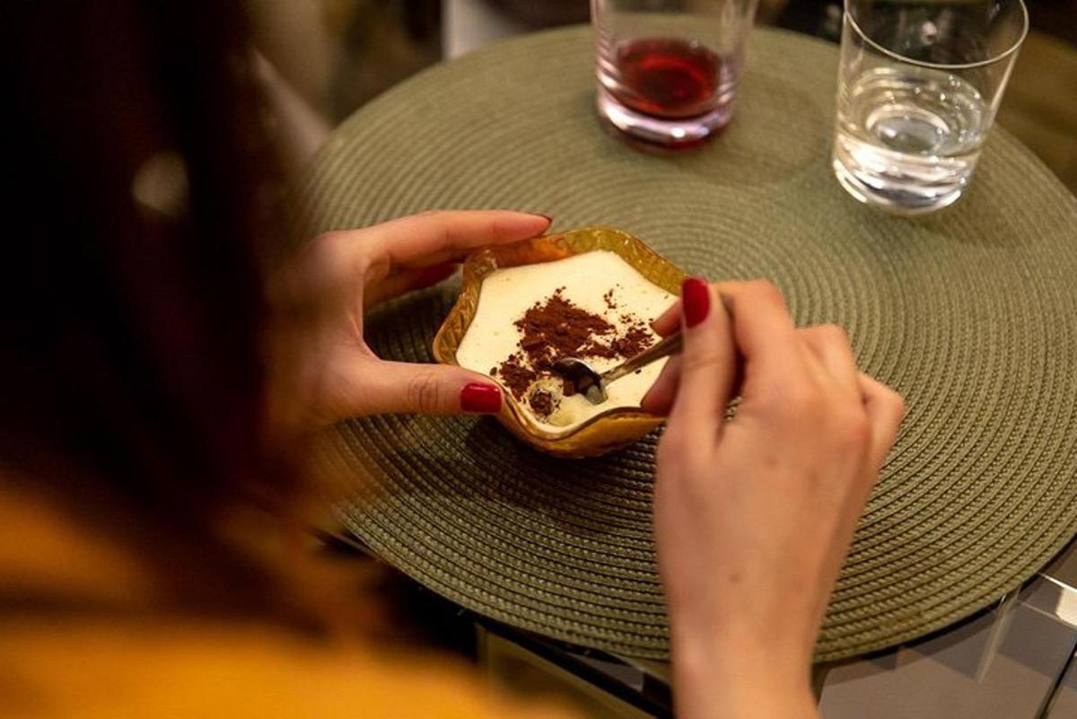 a woman sitting at a table with a plate of dessert