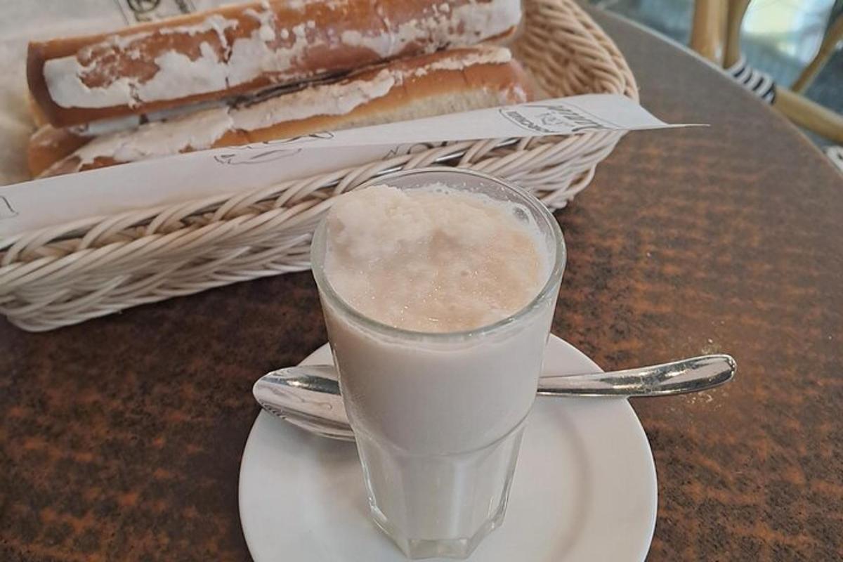 un bicchiere di latte su un piatto accanto a un panino
