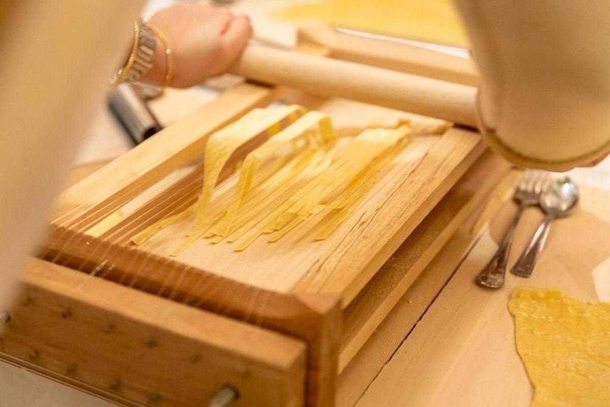 a person cutting up food on a wooden cutting board