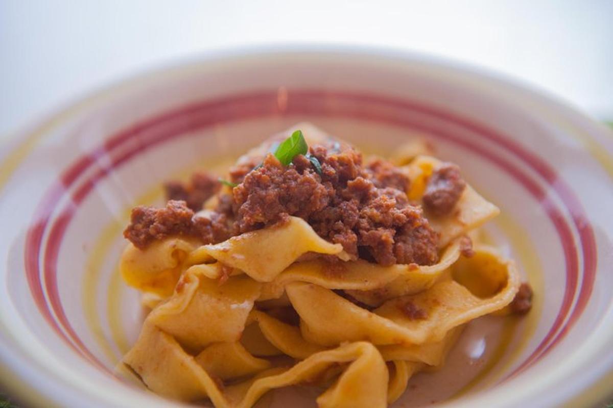 Un tazón de pasta con carne encima.