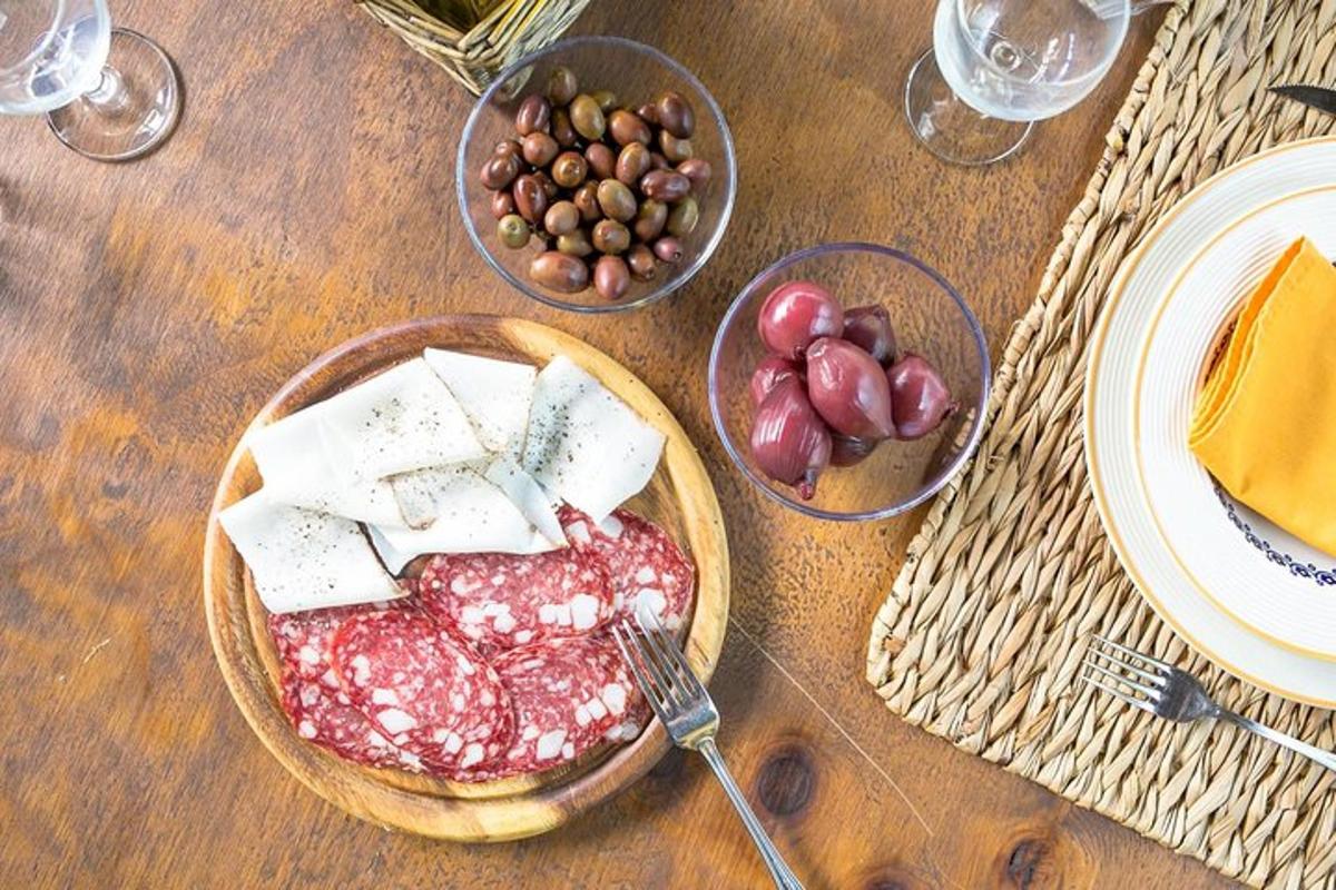un tavolo con un piatto di cibo e una ciotola di formaggio e noci