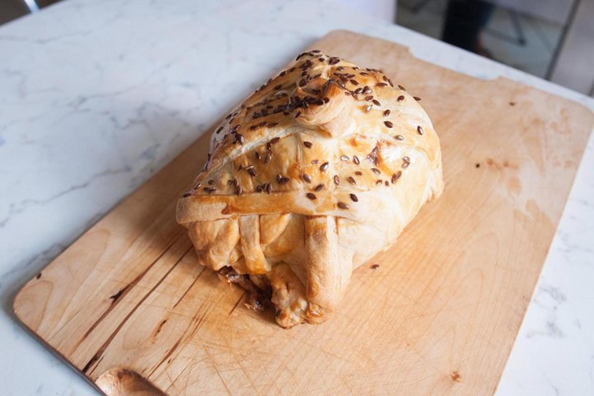 en bagel som står på toppen av et skjærebrett i tre