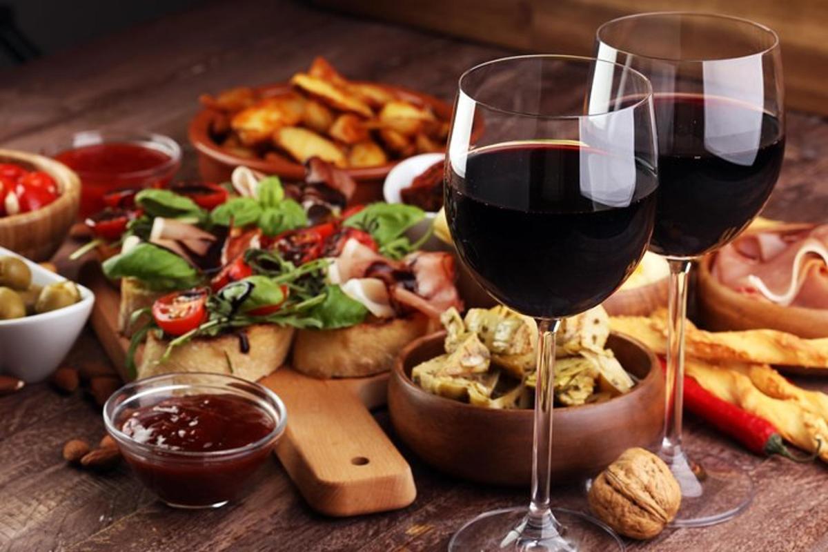 un tavolo con due bicchieri di vino e un piatto di cibo