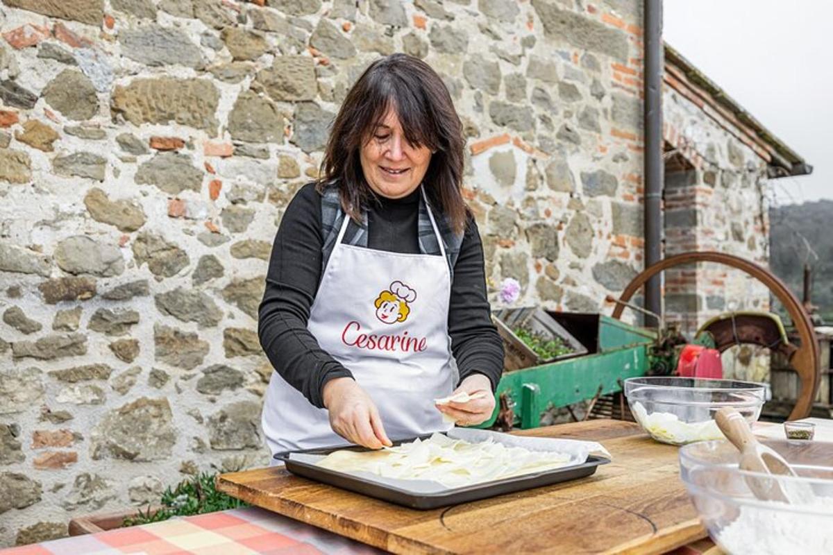 eine Frau in einer Schürze bereitet Essen auf einem Tisch zu