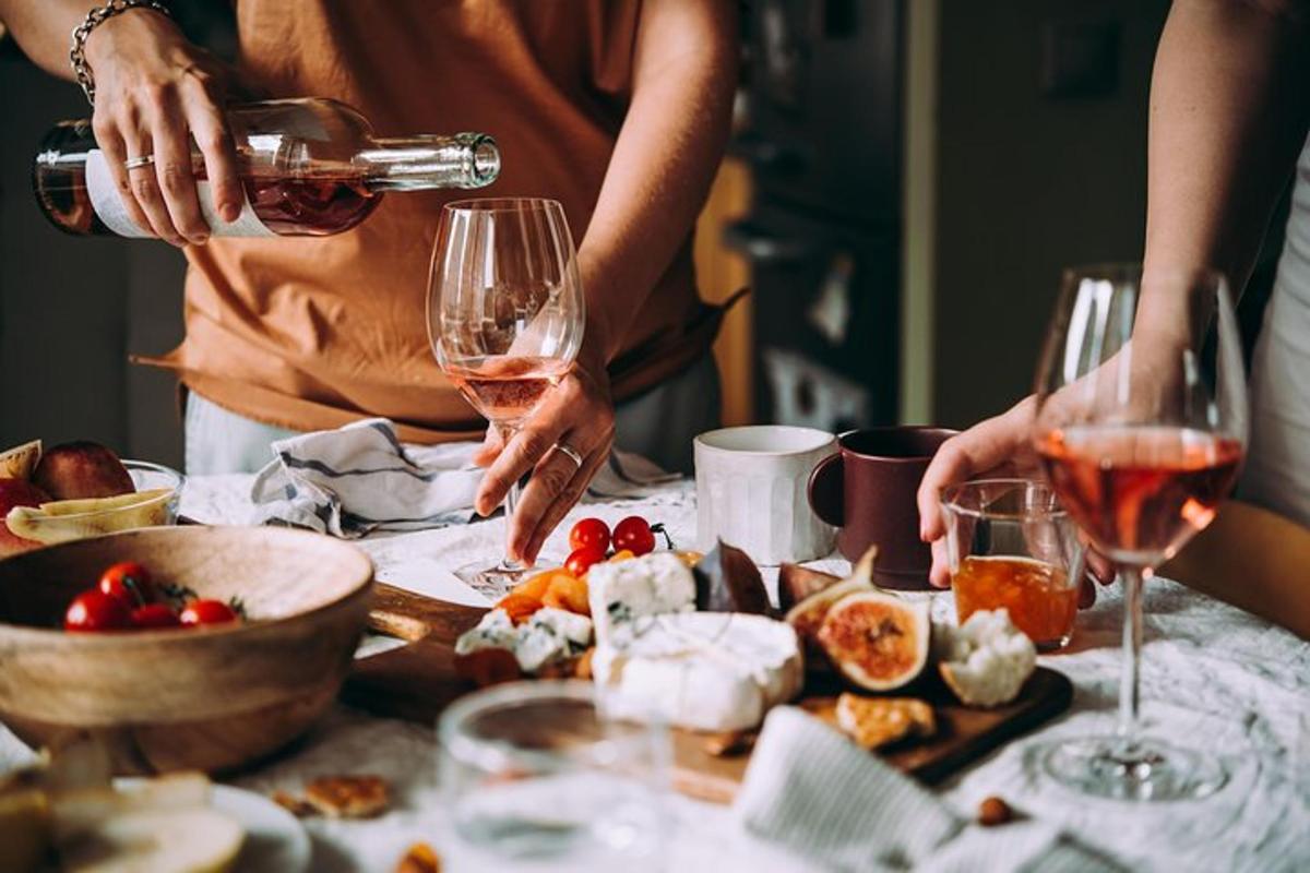 a group of people drinking wine at a table with food