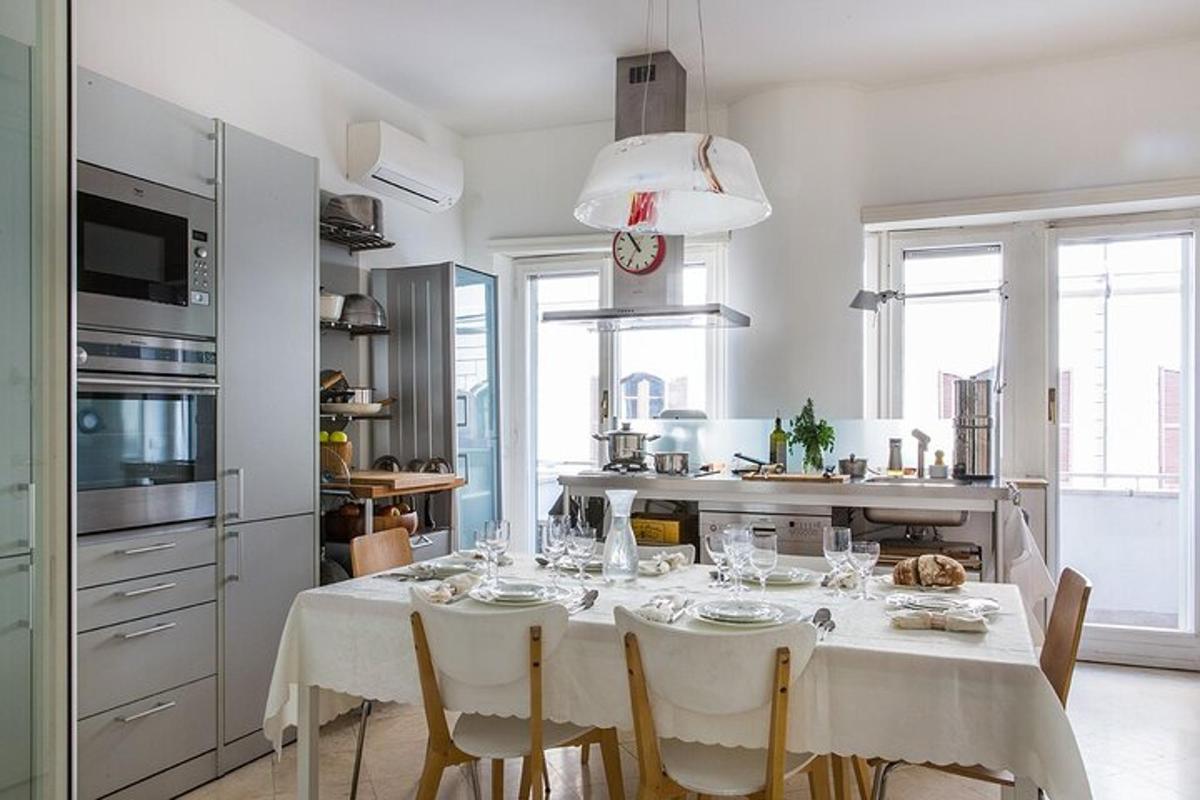 una cocina blanca con una mesa con sillas blancas y una cocina con