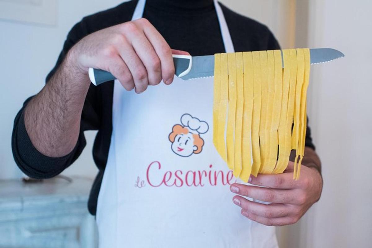 una persona che tiene un pacchetto di pasta su un coltello