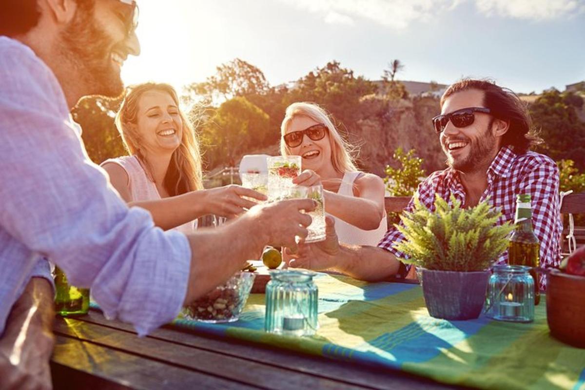 un grup de oameni așezați în jurul unei mese, bând vin