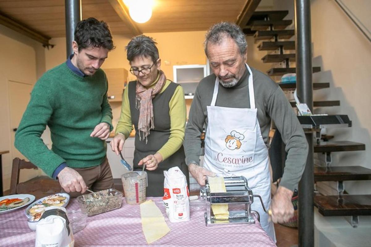 trije moški stojijo okoli mize in pripravljajo hrano