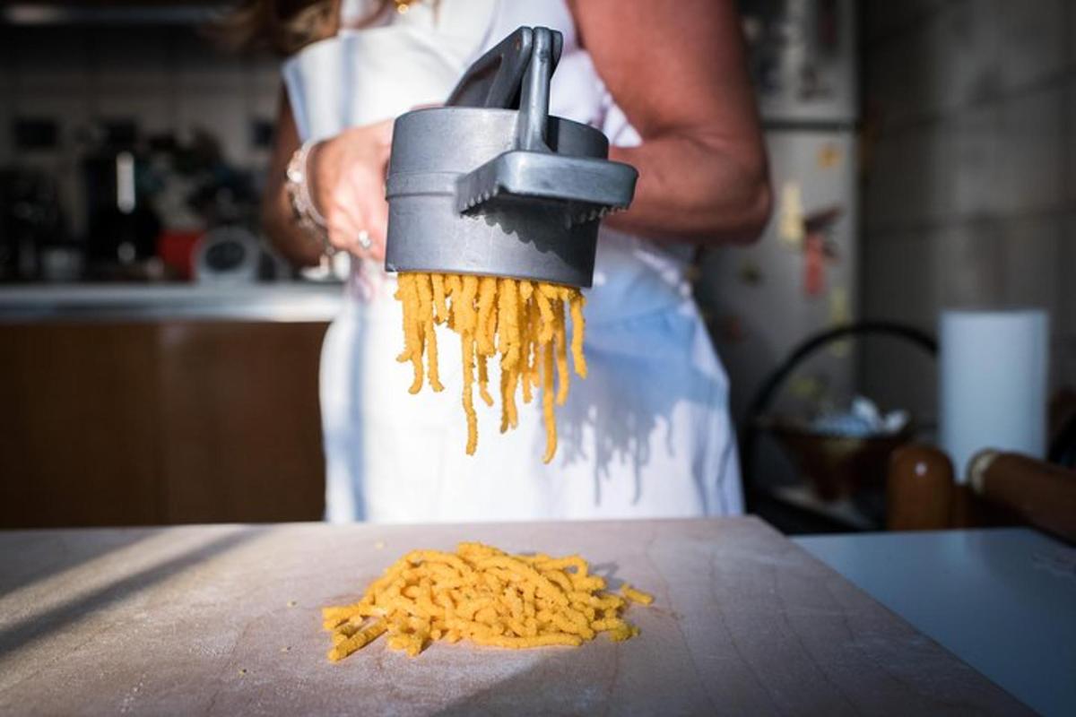 una persona che tiene in mano un mucchio di cibo sul bancone della cucina