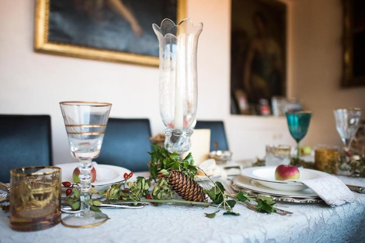 Una mesa con un mantel blanco y un centro de cristal.