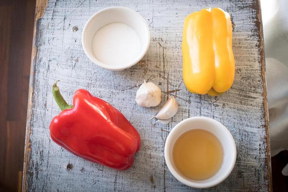 a cutting board with a pepper and two cups of tea