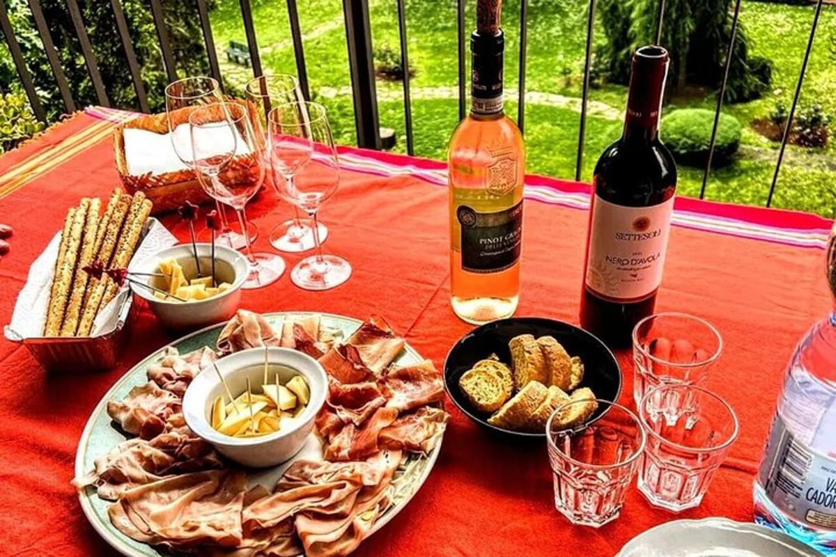 un tavolo con un piatto di cibo e una bottiglia di vino